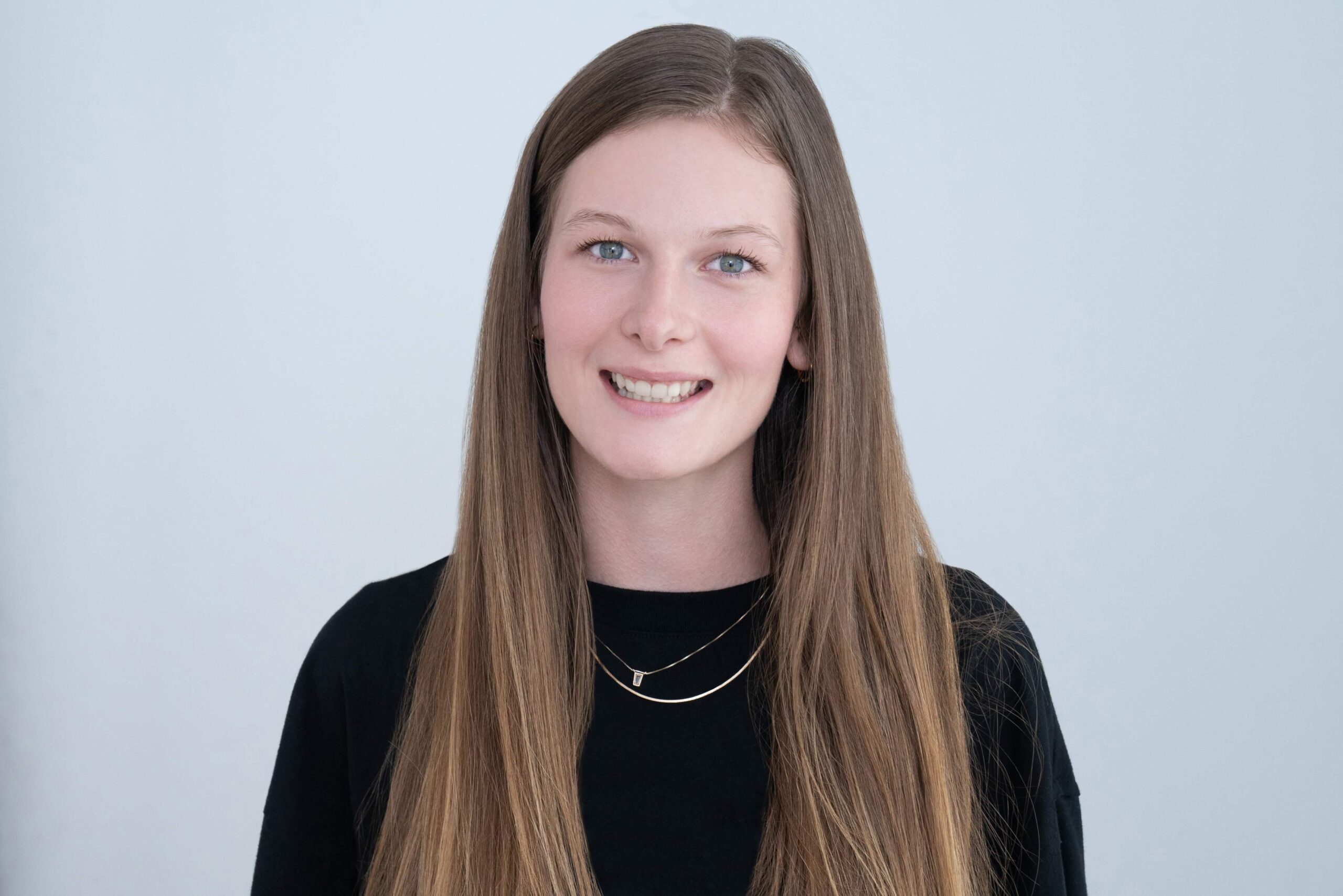 Headshot of Kyleigh Makaryk, a client care and front desk team member at Novo. Kyleigh wears a black t-shirt. Her long blonde hair cascades over her shoulders as she smiles at the camera.